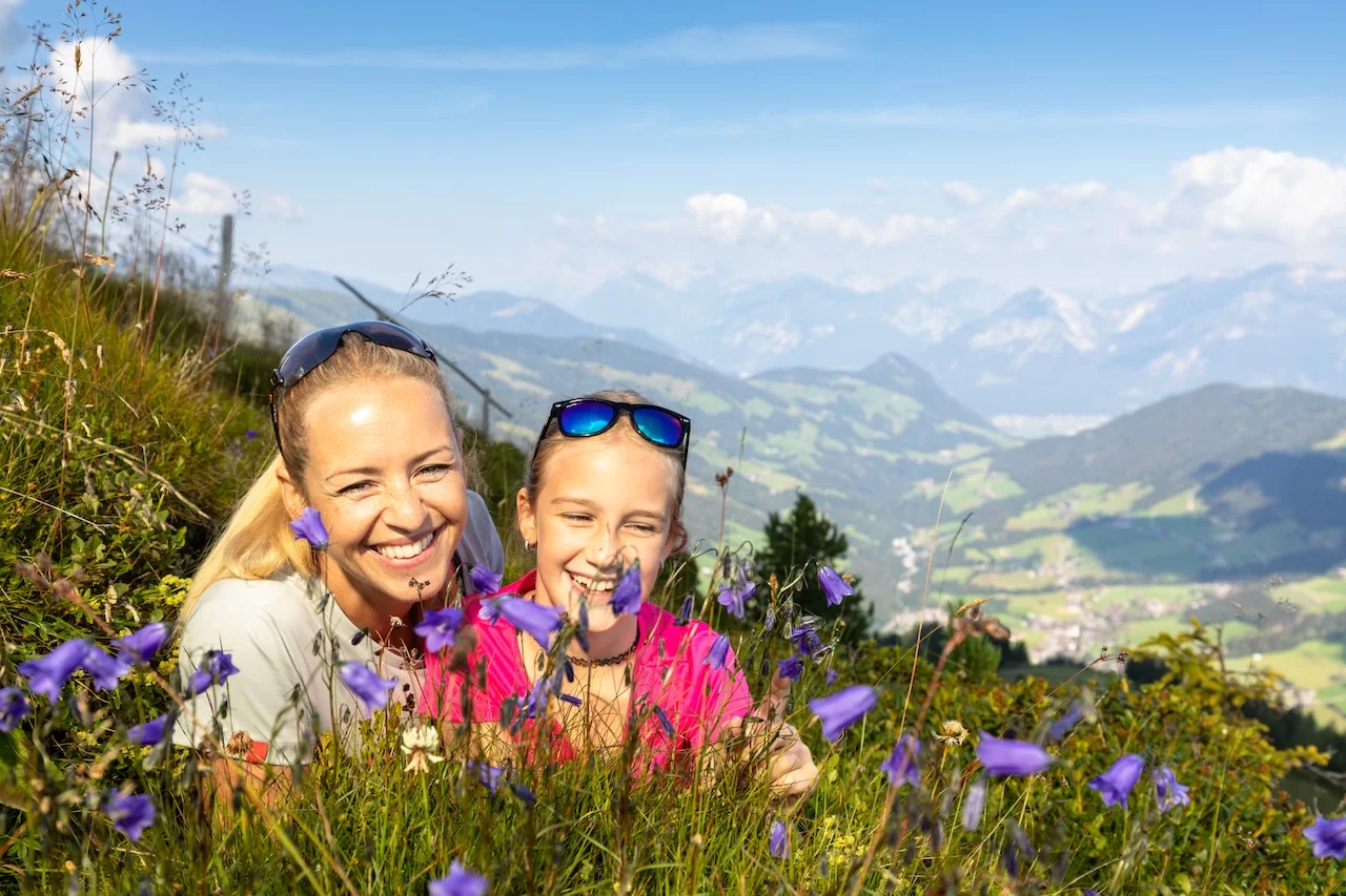 Appartement Rossalm - Mutter und Tochter sitzen zwischen den Blumen 